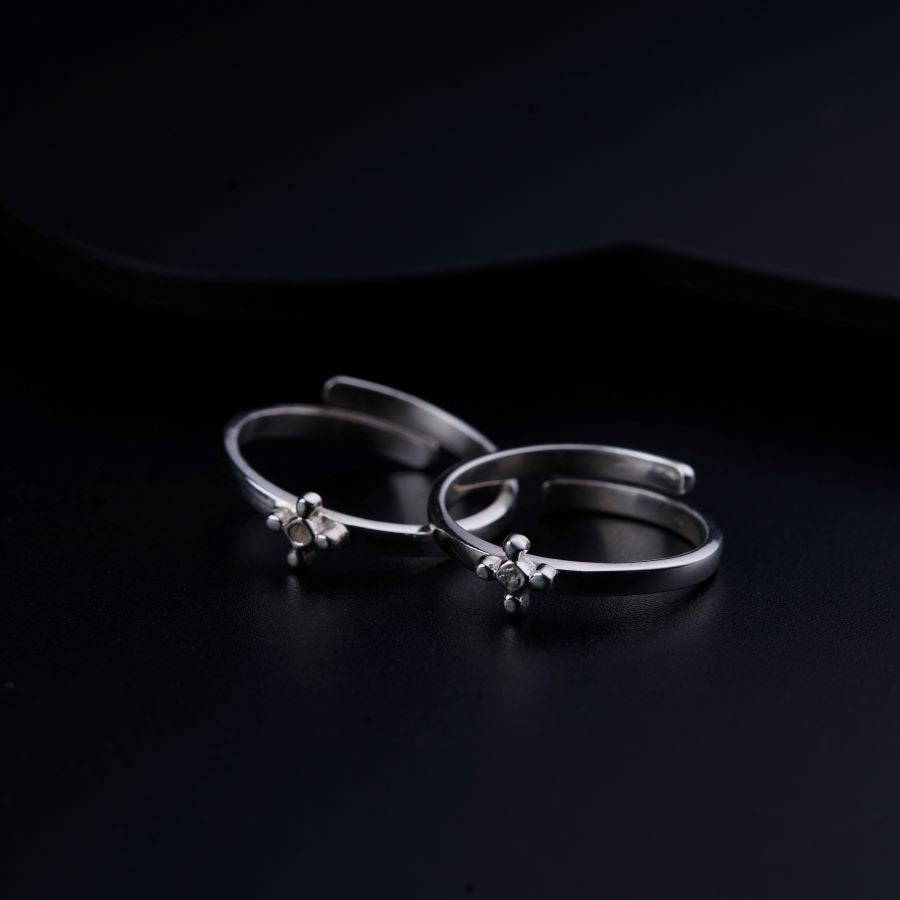 a pair of silver hoop earrings on a black surface