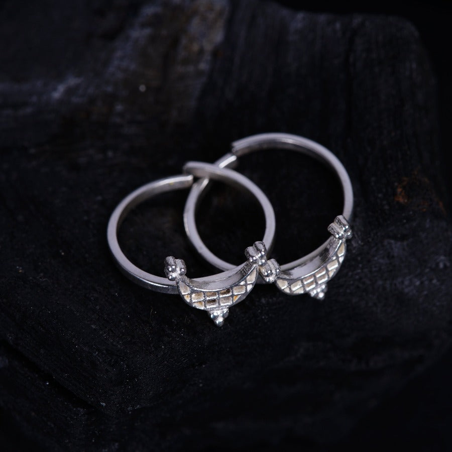 a pair of silver hoop earrings sitting on top of a rock