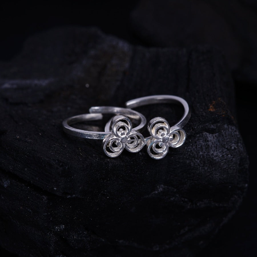 a pair of silver rings sitting on top of a rock