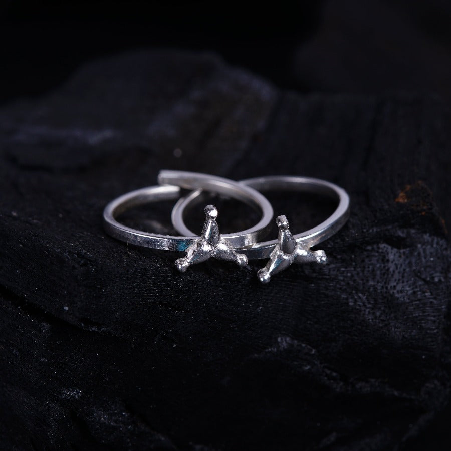 a pair of silver rings sitting on top of a black cloth