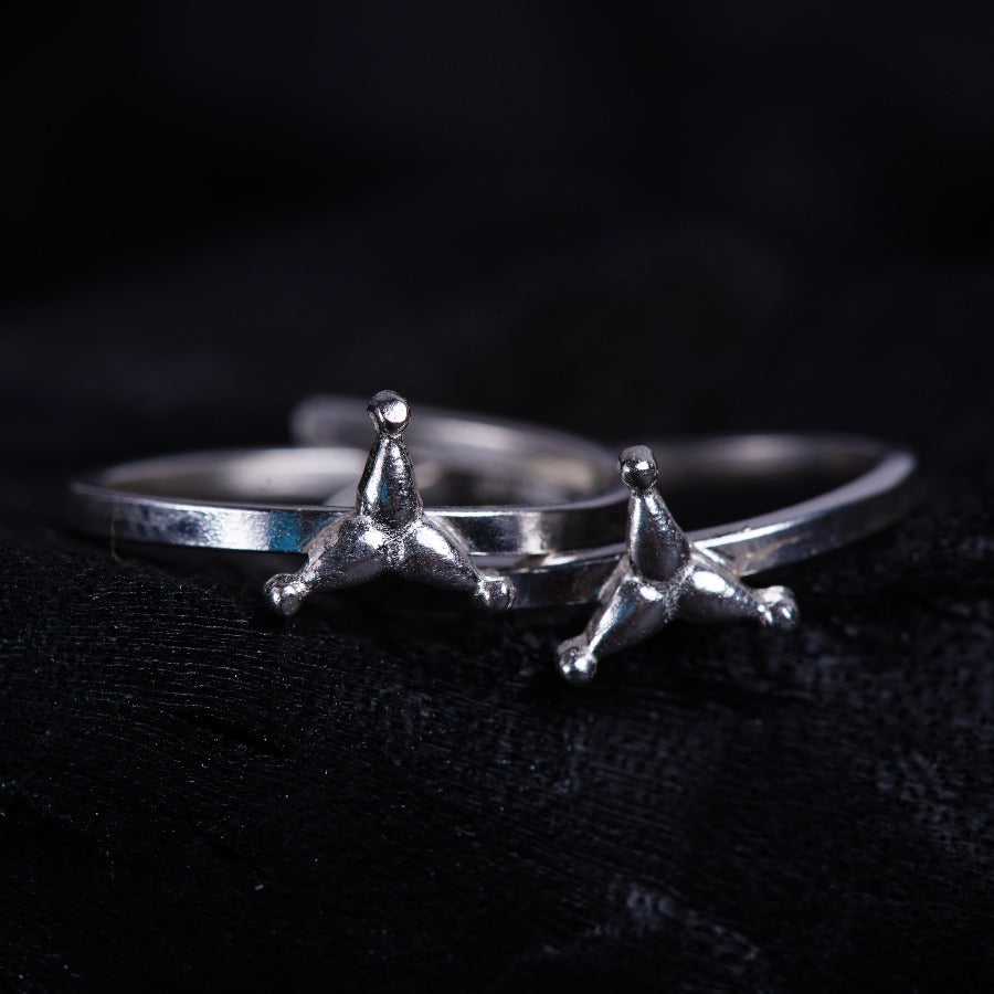 a pair of silver rings sitting on top of a black cloth