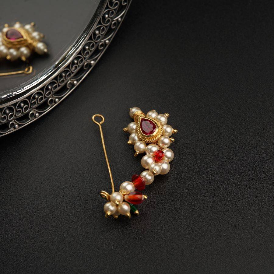 a close up of a pair of earrings and a mirror
